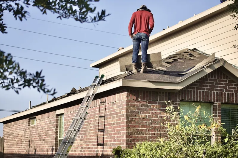 Professional roofer working on a residential roof in Elbaville